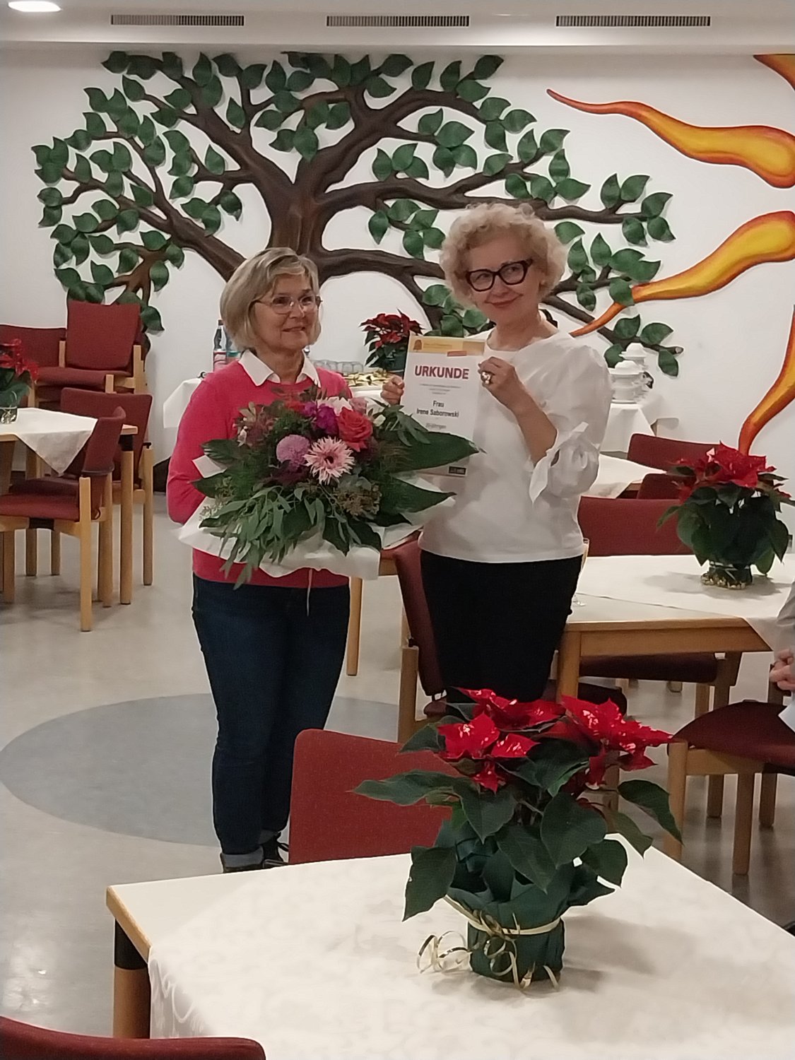 Einrichtungs- und Pflegedienstleitung Roman Hippe (rechts) bedankt sich bei Irene Saborowski für 20 Jahre Zugehörigkeit, Treue und Loyalität. 