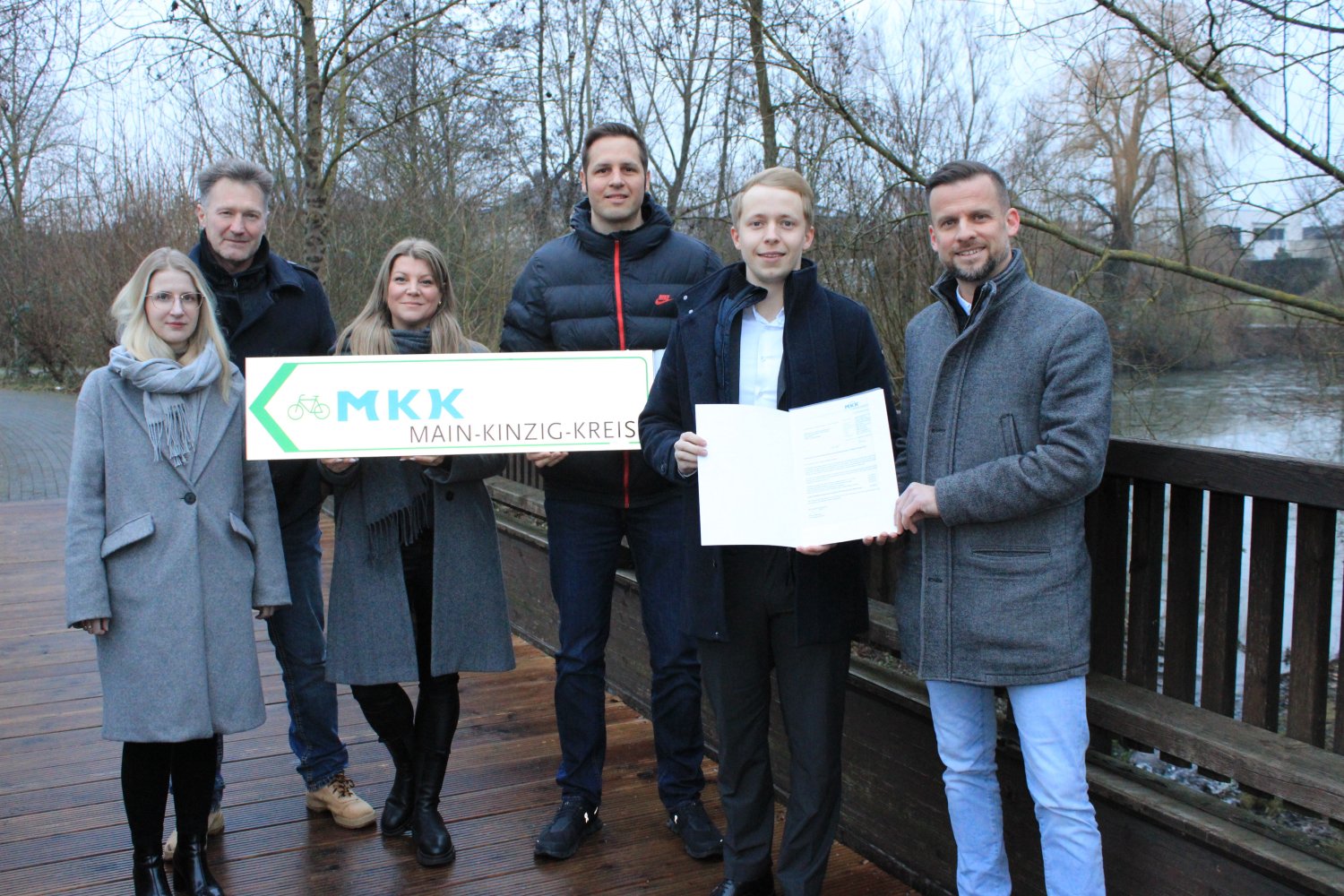 Bürgermeister Timo Greuel nimmt den Förderbescheid vom Kreisbeigeordneten Jannik Marquart und dem Radverkehrsbeauftragten Elmar Sachs entgegen, im Beisein von Amtsleiterin Verena Margraf, Teamleiter Mario Günther und Lisa Müller (v.re.).