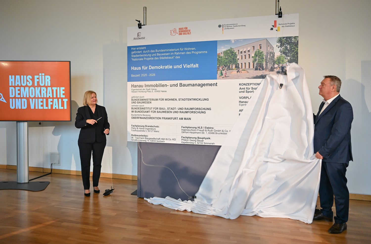 Zum symbolischer Baubeginn am Tag nach dem fünften Jahrestag des Anschlags vom 19. Februar enthüllten heute Bundesinnenministerin Nancy Faeser und Hanaus Oberbürgermeister Claus Kaminsky das Bauschild.