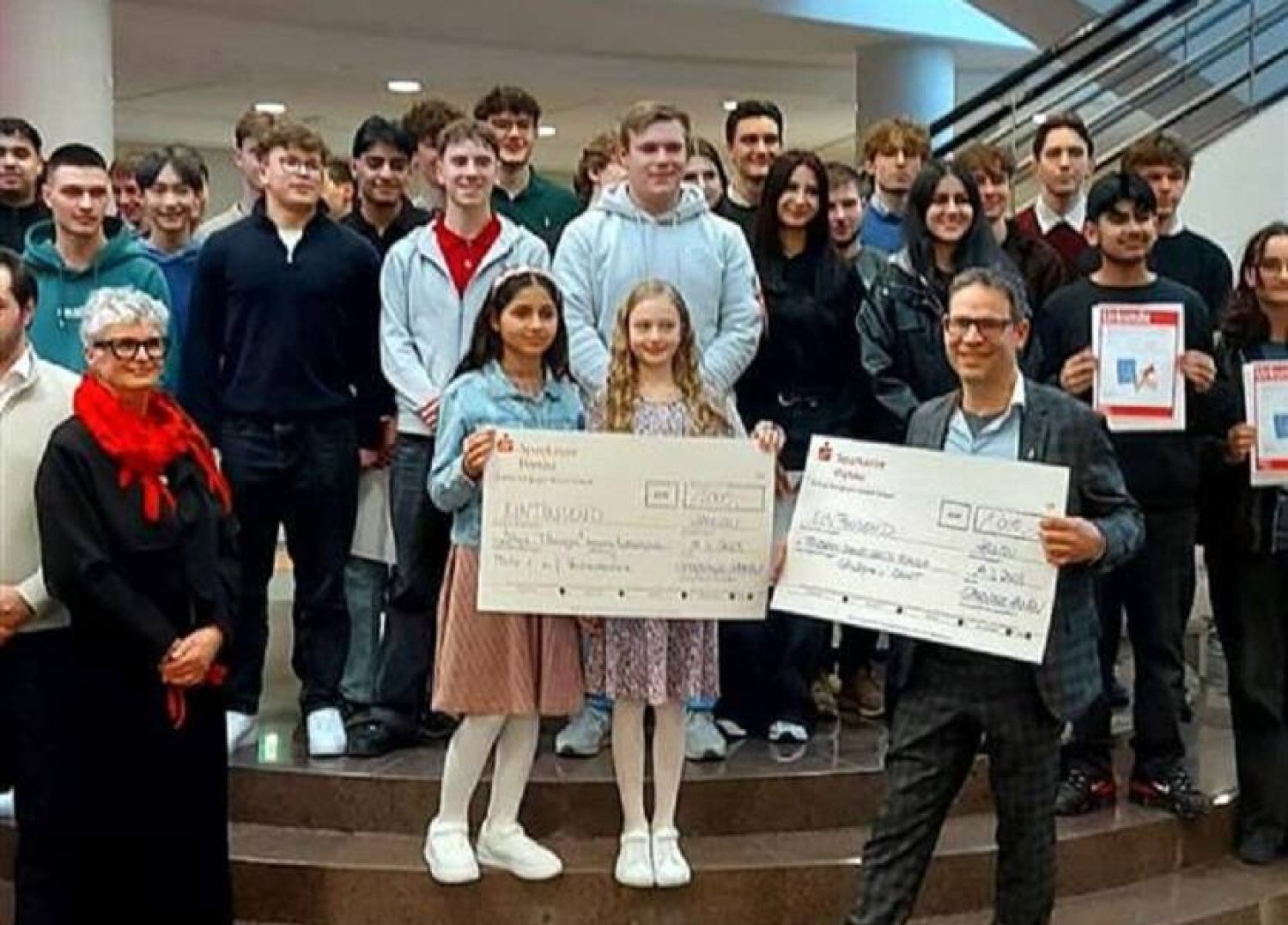 Juliane Münker und Lilian Al Hagali und ihr Lehrer Alexander Eckhardt nehmen den Preis für ihren Sieg beim Börsenspiel der Sparkasse Hanau entgegen.