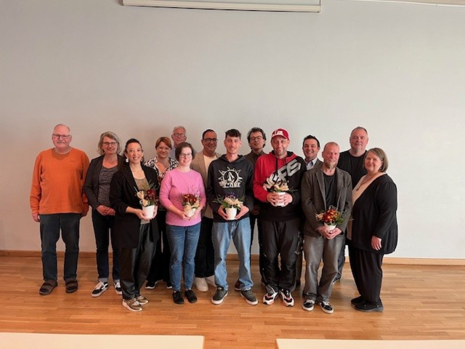Begrüßung der neuen Kolleginnen und Kollegen (mit Blumen) im kleinen Saal der Erlenhalle. 