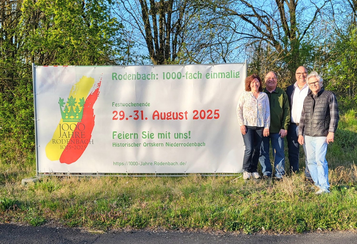 ürgermeister Schejna, Martina Eichhöfer, Martin Hiltner und Richard Uhl von der Arbeitsgruppe Merchandising und Medien vor der Banner-Werbung zum Jubiläumsfest