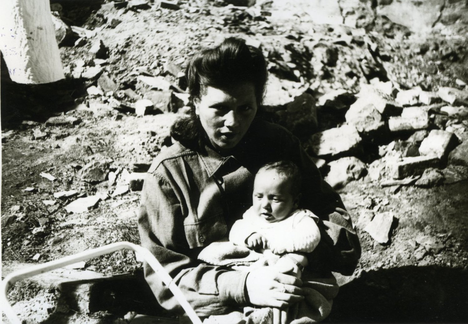 Eine Frau hält ihr Baby im Trümmerfeld von Hanau nach dem Kriegsende 1945.
