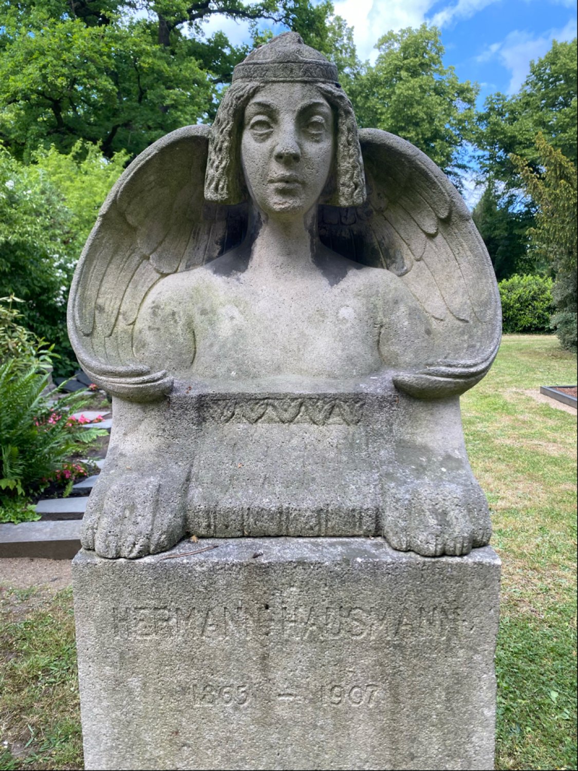 Grabmal für Hermann Hausmann Sphinx von dem Hanauer Zeichner und Bildhauer Hermann Hausmann (1865-1907). Das Kleindenkmal wurde kürzlich restauriert und an der Dettinger Straße in der Nähe des Gräberfeldes der Familie Heraeus neu positioniert.