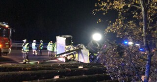 Schwierige Bergung: der Lkw liegt hinter der Leitplanke.