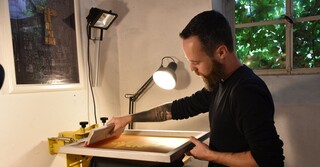 Von Hand werden die Textilien bedruckt.