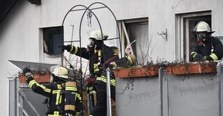 Mit Atemmasken machen sich die Einsatzkräfte ein Bild vom Ausmaß des Brandes im Haus.