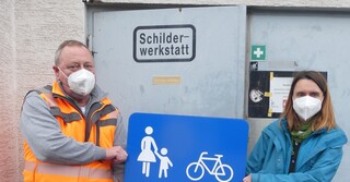 Bauhofleiter Matthias Barnikol und seine Stellvertreterin Heidrun Hess mit einem Eigenprodukt vor der Schilderwerkstatt. 