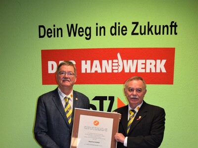Obermeister Walter Ebert (rechts) überreicht Manfred Köhler die Urkunde zum Ehrenvorstandsmitglied
