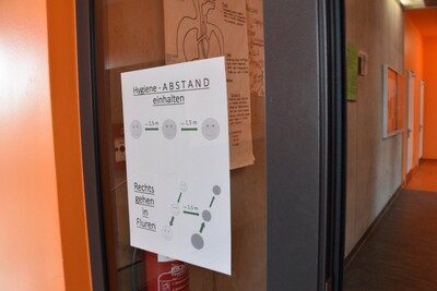 Überall in der Schule verteilt wird auf den Mindestabstand hingewiesen.