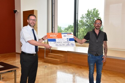 Landrat Thorsten Stolz (links) übergibt den ersten Preis an Sieger Dennis Korn.