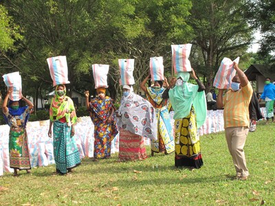 Die Frauen in Mamba Village tragen ihre Hilfspakete zurück zu ihren Familien.