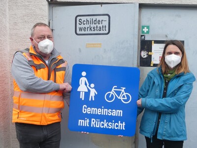 Bauhofleiter Matthias Barnikol und seine Stellvertreterin Heidrun Hess mit einem Eigenprodukt vor der Schilderwerkstatt. 