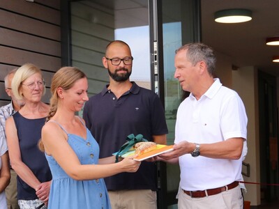 Architekt Bernd Winter übergibt im Beisein seines Projektleiters Niko Kirstein (hinten Mitte) den symbolischen Schlüssel für die neue Kita an Anita Paradies.