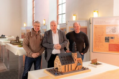 Die Dioramen- und Modellbauer Dirk Klitsch (li.) und Rainer Stephan mit dem Kurator der Ausstellung Erhard Bus (Mitte) am Modell der Marienkirche. Zu sehen zwischen 3. und 10. Juni im Ajoki in der Hanauer Altstadt beim - <i>Foto: United Power Fields </i>